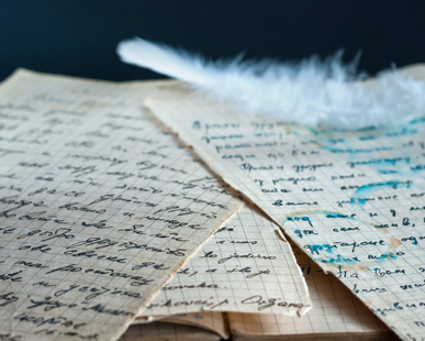 white feather on old documents