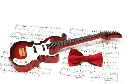 Musical notes, guitar and bow tie on white