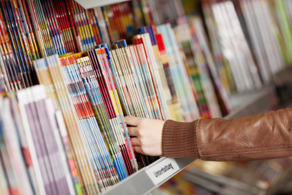 Woman's Hands Choosing Magazines From Shelf